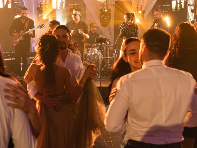 Invitați dansând lângă scenă, cu trupa cântând în spatele lor