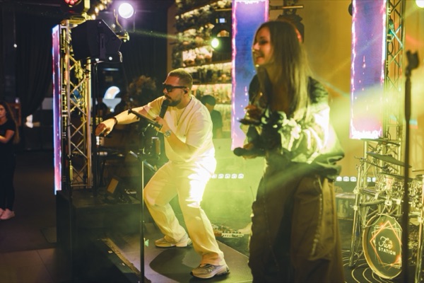 Matei și Claudia cântând pe scenă, în lumină galbenă