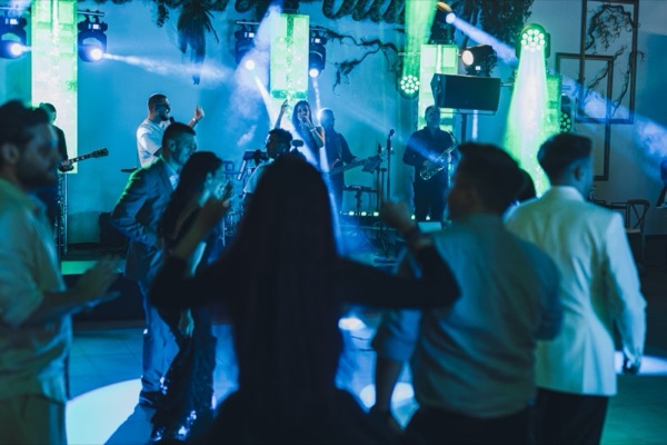 Invitați dansând în lumină albastră, în fața scenei
