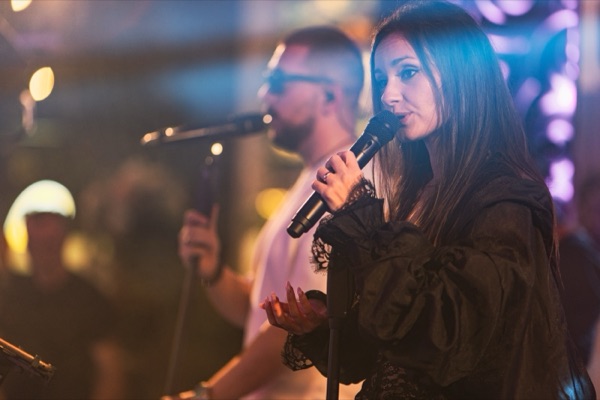Claudia cântând, cu Matei în spatele ei