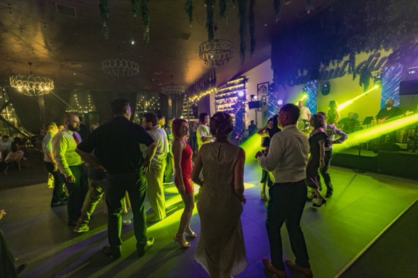 Invitați dansând în fața scenei, sub verdeața salonului