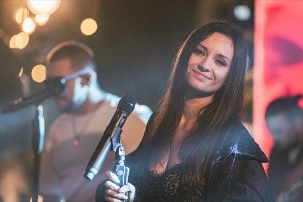 Claudia zâmbind, cu microfonul în mână