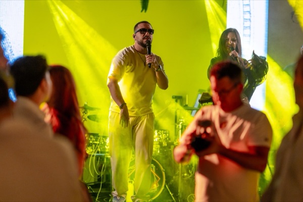 Matei cântând printre invitați, în lumina galbenă