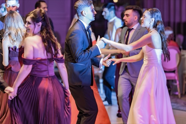 Mireasa dansând cu invitații, în lumină violet